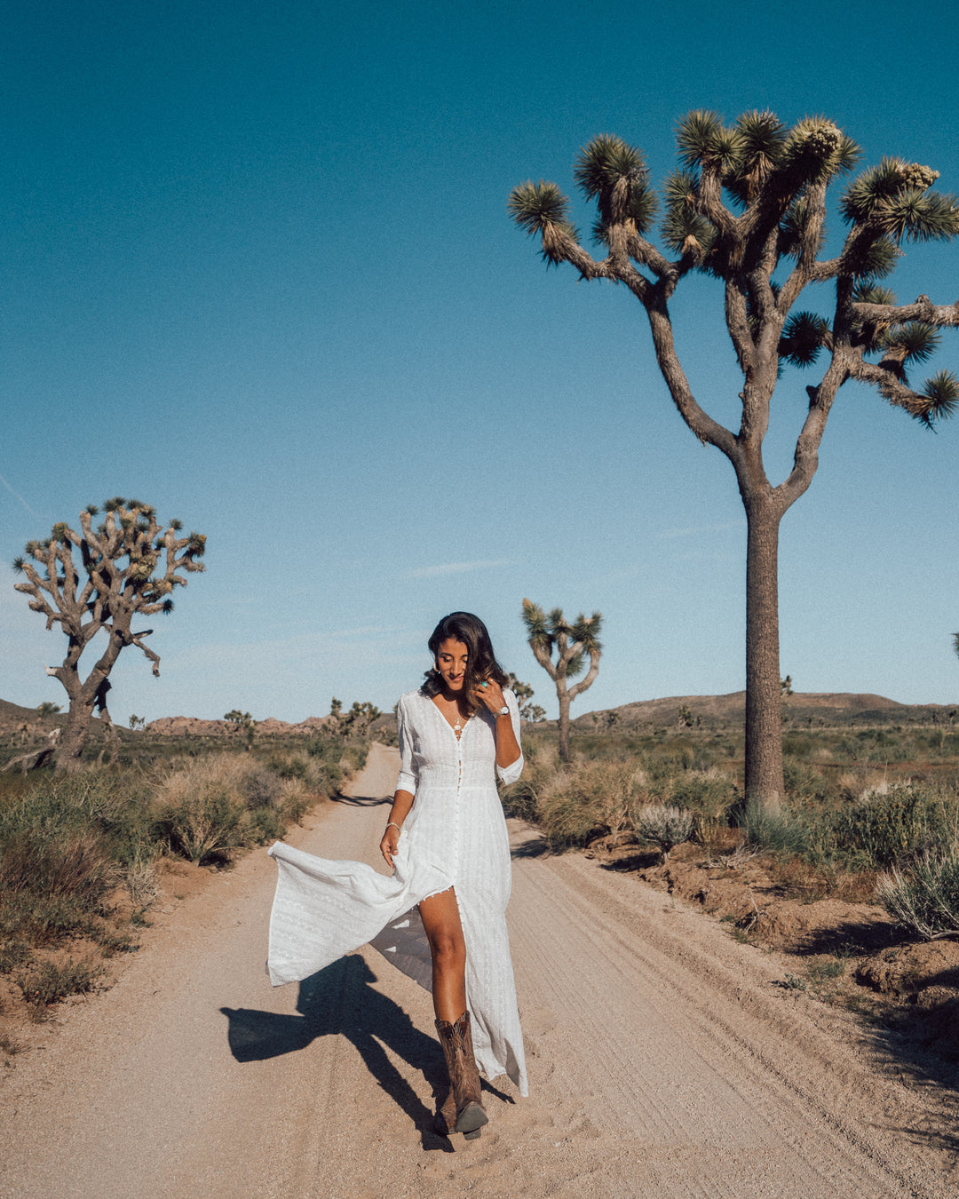 Influencer @maya_gypsy visiting Joshua Tree in white boho lace dress